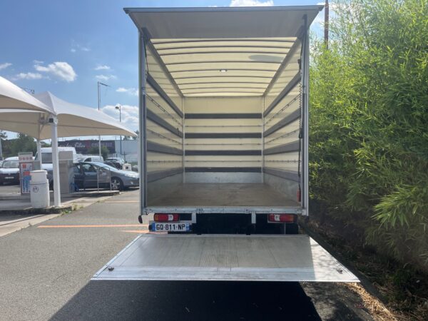 Camion de déménagement ouvert sur un parking.