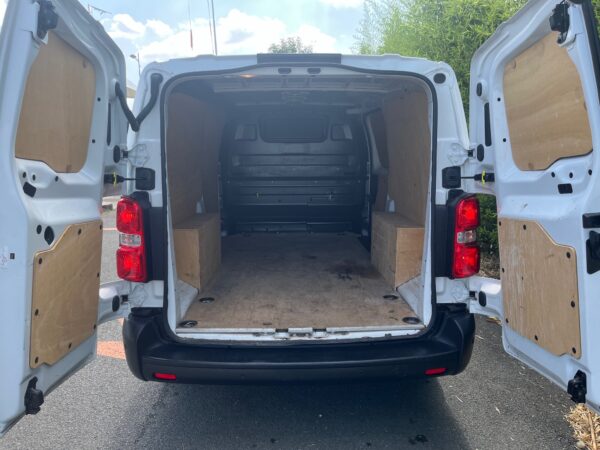 Intérieur d'une camionnette vide avec portes ouvertes.